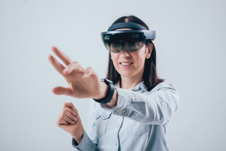 Woman wearing augmented reality goggles. White background
