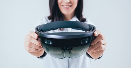 Woman wearing augmented reality goggles. White backgroundの写真素材