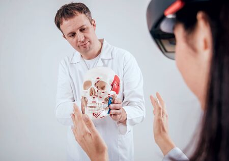 Doctor uses augmented reality goggles and human skeletonの写真素材
