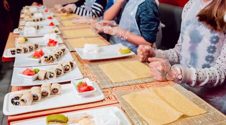 Children prepare sushi and rolls. Master-class restaurant.の写真素材