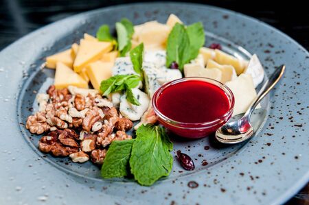 Sliced cheese with nuts on a plateの写真素材