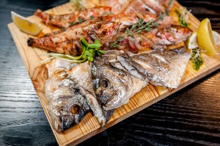 Fried fish on a big wooden boardの写真素材