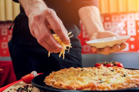 The cook is making pizza. Adds the ingredients. A restaurantの写真素材