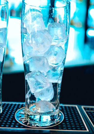 Light coctail with ice cubes. Blue light backgroundの写真素材