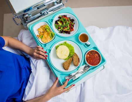 Tray with breakfast for the young female patient. The young woman eating in the hospital. Hospital food conceptの写真素材