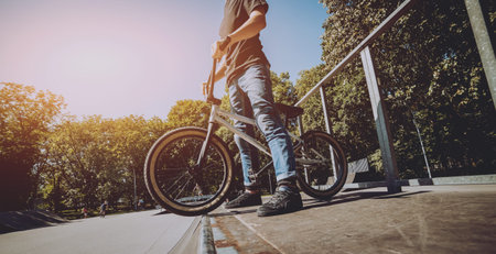Bmx rider performing tricks at skatepark. Background
