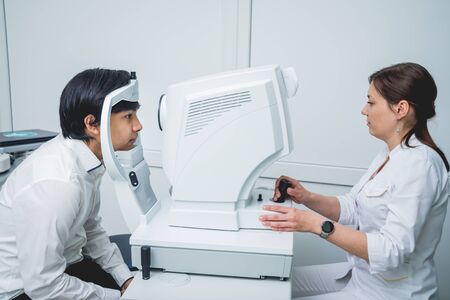 Consultation with an ophthalmologist. Young asian man and woman doctorの写真素材