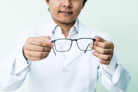 Asian man ophtalmologist standing at hospital and looking at camera.の写真素材