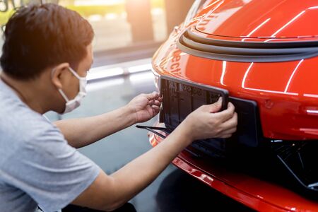 Technician changing car plate number in service center.の写真素材