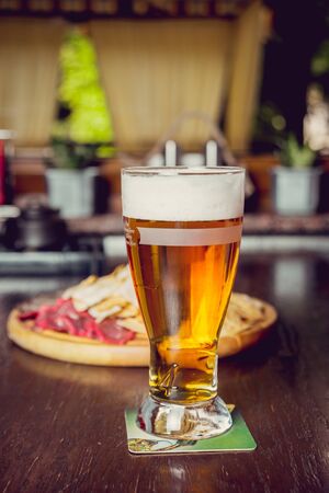 Meat and chips on a wooden plate with beer. Restaurantの写真素材
