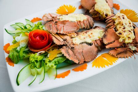 Cooked lobster with vegetables on a white plate. Restaurantの写真素材