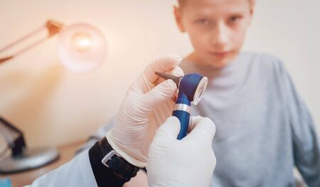 Doctor examines boy ear with otoscope. Medical equipment.の写真素材