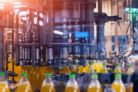 Automatic filling machine pours water into plastic PET bottles. Brewing production. Industrial background.の写真素材