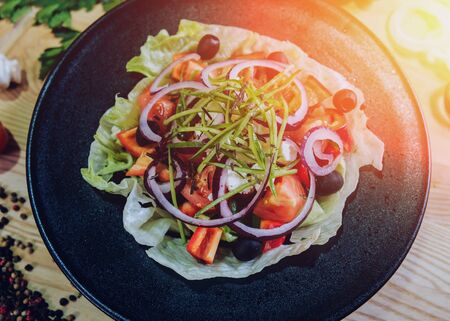 Greek salad from cabbage, olives and mozzarella on the black plateの写真素材