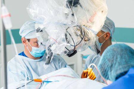 Brain surgery. Group of surgeons in operating room with surgery equipment.の写真素材