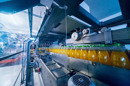 Beverage factory interior. Conveyor with bottles for juice or water. Modern equipmentsの写真素材