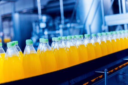 Conveyor with bottles for juice or water. Beverages factory equipments. Backgroundの写真素材