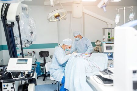 Brain surgery. Group of surgeons in operating room with surgery equipment.の写真素材