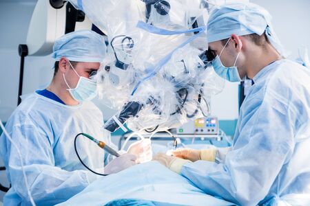 Spinal surgery. Group of surgeons in operating room with surgery equipment. Laminectomy. Modern medical backgroundの写真素材