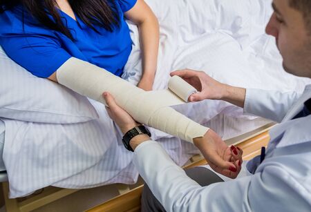 Male doctor bandaging hand of female patients.の写真素材