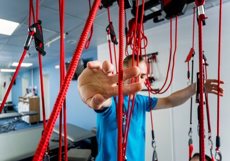 Physiotherapy. Suspension training therapy. Young man doing fitness therapyの写真素材