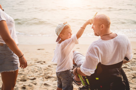 Disabled man in a wheelchair with his family on the beach.