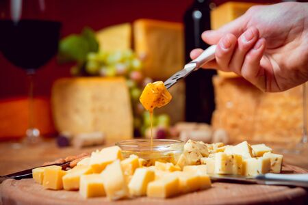 Knife with piece of cheese on a dark table.の写真素材