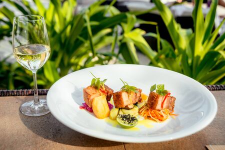 Pieces of meat with vegetables on a white plate.の写真素材