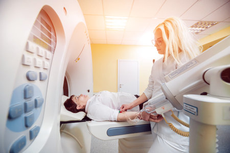 Doctor and patient in the room of computed tomography at hospital. Medical equipment.