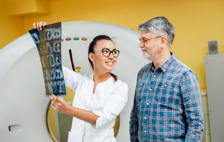 Radiologist with an male patient looking at x-ray.