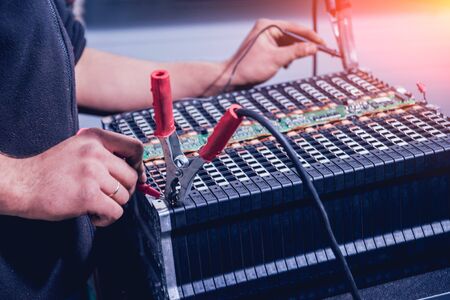 Charging the batteries of the elecric motor. Disassembling the battery of an electric vehicle engine. Car serviceの写真素材