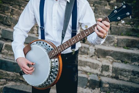View of musician playing banjo at the street. Authentic backgroundの写真素材