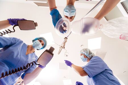 Doctors give resuscitation to a male patient in the emergency room. Cardiac massage. Defibrillationの写真素材