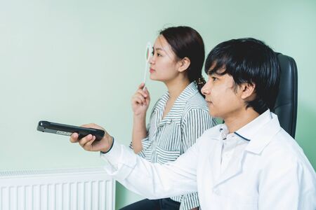 Consultation with an ophthalmologist. Young asian woman and doctorの写真素材