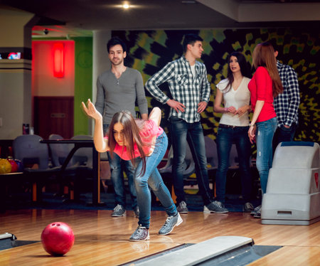 Cheerful friends at the bowling alley with the balls.