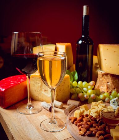 Cheese and wine on a dark table.の写真素材
