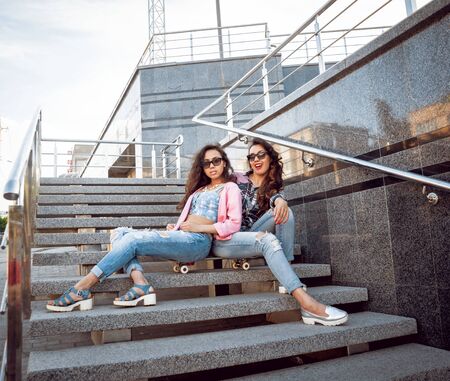 Young girls with skateboard sitting on the stairsの写真素材