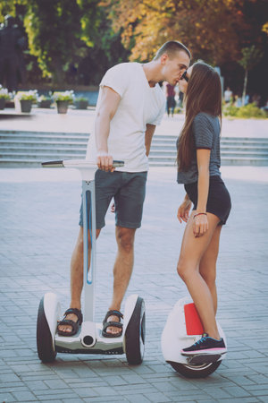 Young couple driving on monowheel in the park