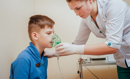 Boy making inhalation with nebulizer at clinic.