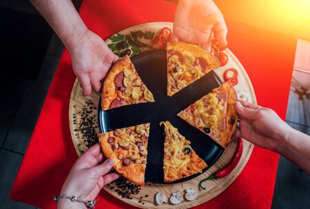 A slice of pizza in his hand. A restaurant.の写真素材