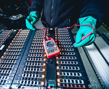 Charging the batteries of the elecric motor. Disassembling the battery of an electric vehicle engine. Car serviceの写真素材