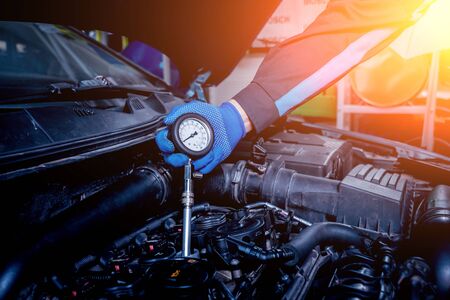 infrared laser thermometer in hand. Motor temperature measurement in the car serviceの写真素材