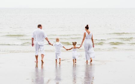 Happy young family on the sunset at the beach. Lifestyleの写真素材