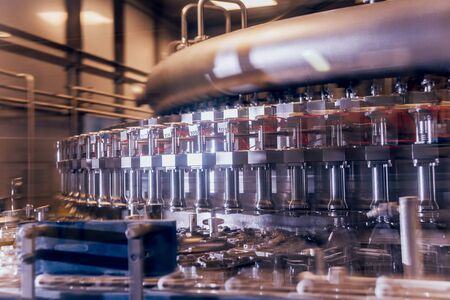 Automatic filling machine pours water into plastic PET bottles. Brewing production. Industrial background.の写真素材