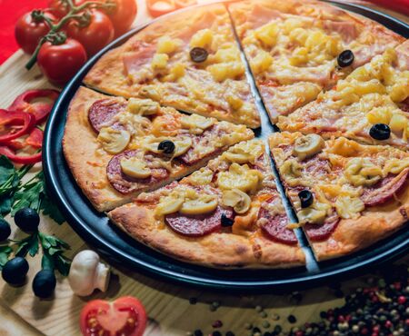 Large hot pizza on the black plate. Restaurant.の写真素材