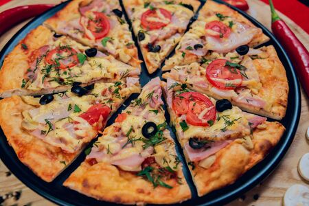 Large hot pizza on the black plate.の写真素材
