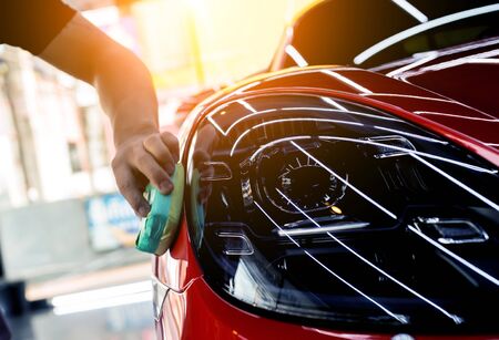 Car service worker applying nano coating on a car detailの写真素材