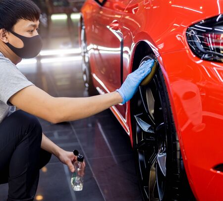 Car service worker polishing car wheels with microfiber cloth.の写真素材
