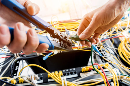 Network engineer working in server room. Connecting network cables to switches