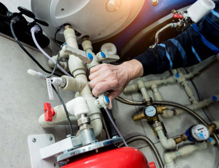 Heating engineer fixing modern heating system in boiler room. Automatic control unit. Engineering...